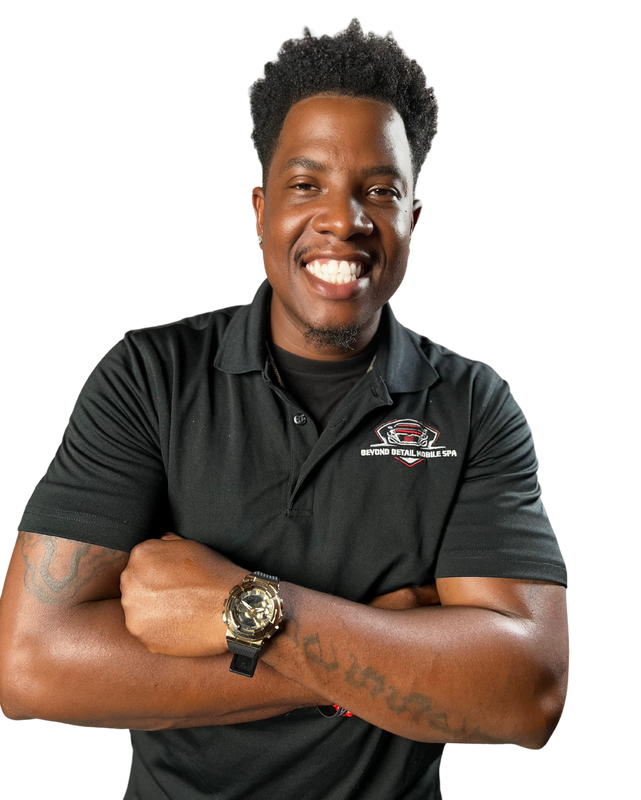 Charles, owner of Beyond Detail, smiling with arms crossed in a black Beyond Detail Mobile Spa polo and a gold watch