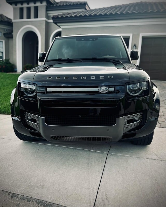 Glossy black Land Rover Defender detailed and shining in a driveway