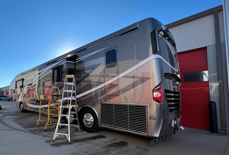 A large motorhome RV being washed and detailed on-site